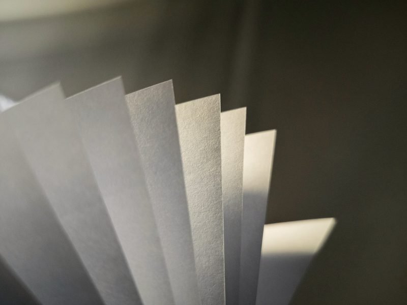 Sheets of paper fanned out in raking light